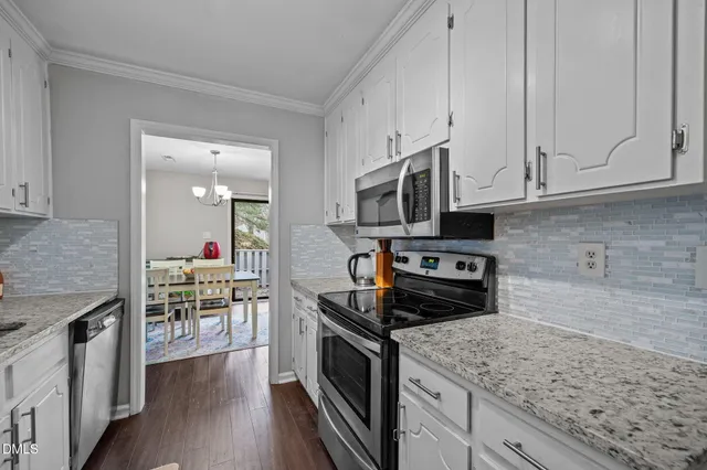 a kitchen with stainless steel appliances granite countertop a stove a sink and a microwave