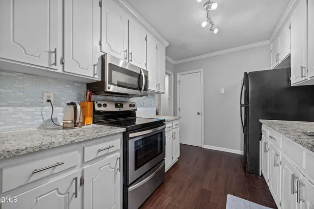 a kitchen with stainless steel appliances granite countertop a refrigerator stove and sink