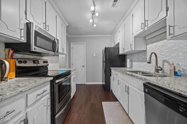 a kitchen with stainless steel appliances granite countertop a sink stove and refrigerator