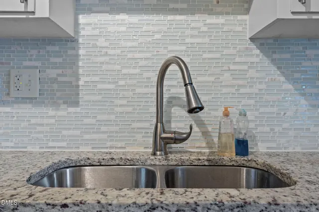 a close view of a sink a granite counter top a sink and a granite counter top