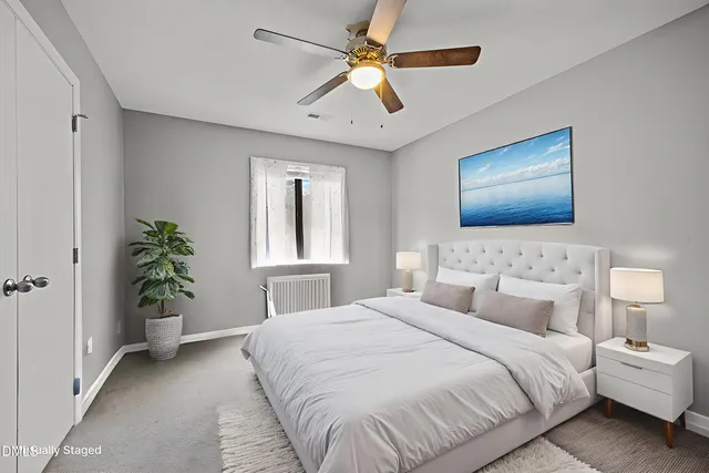 a bedroom with a large bed and a chandelier