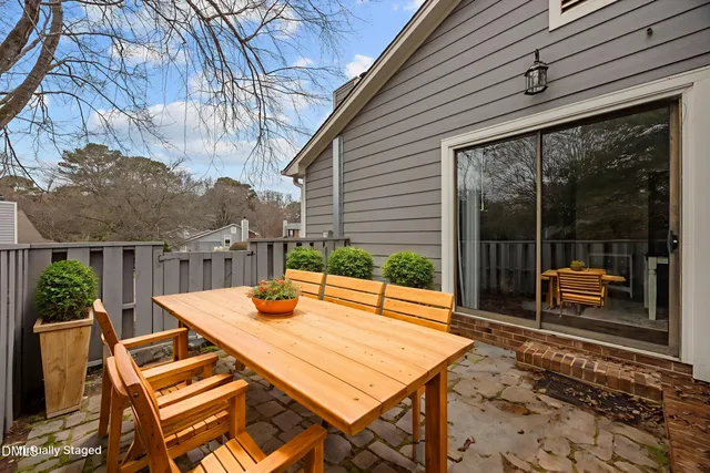 a view of a patio with a dining table and chairs with wooden floor