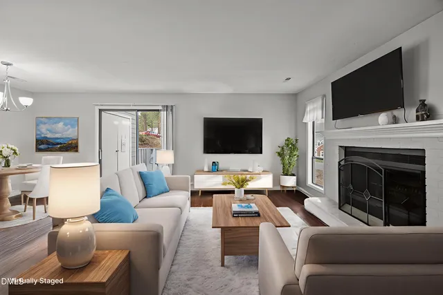 a living room with furniture a flat screen tv and a fireplace