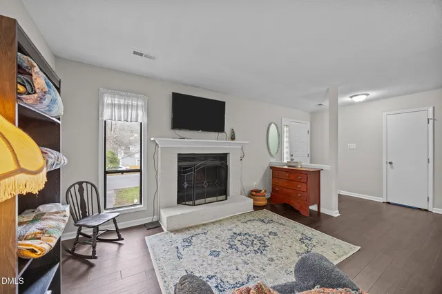 a living room with furniture a fireplace and flat screen tv