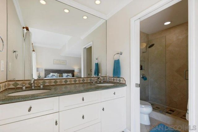 a bathroom with a granite countertop sink mirror and toilet