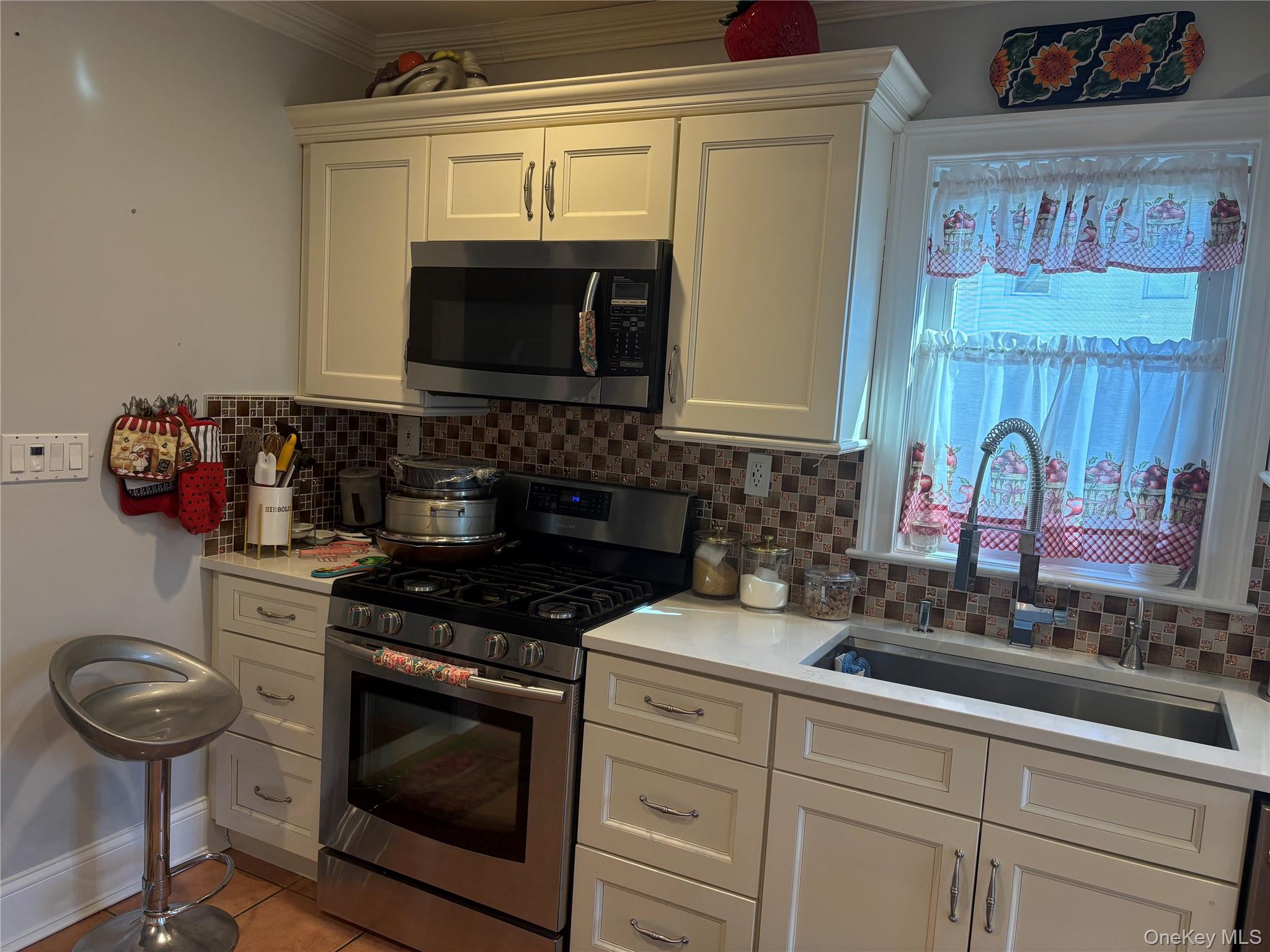 25 Rutland Road Freeport, NY 11520 - Photo 11 of 31 a kitchen with stainless steel appliances a stove and a microwave