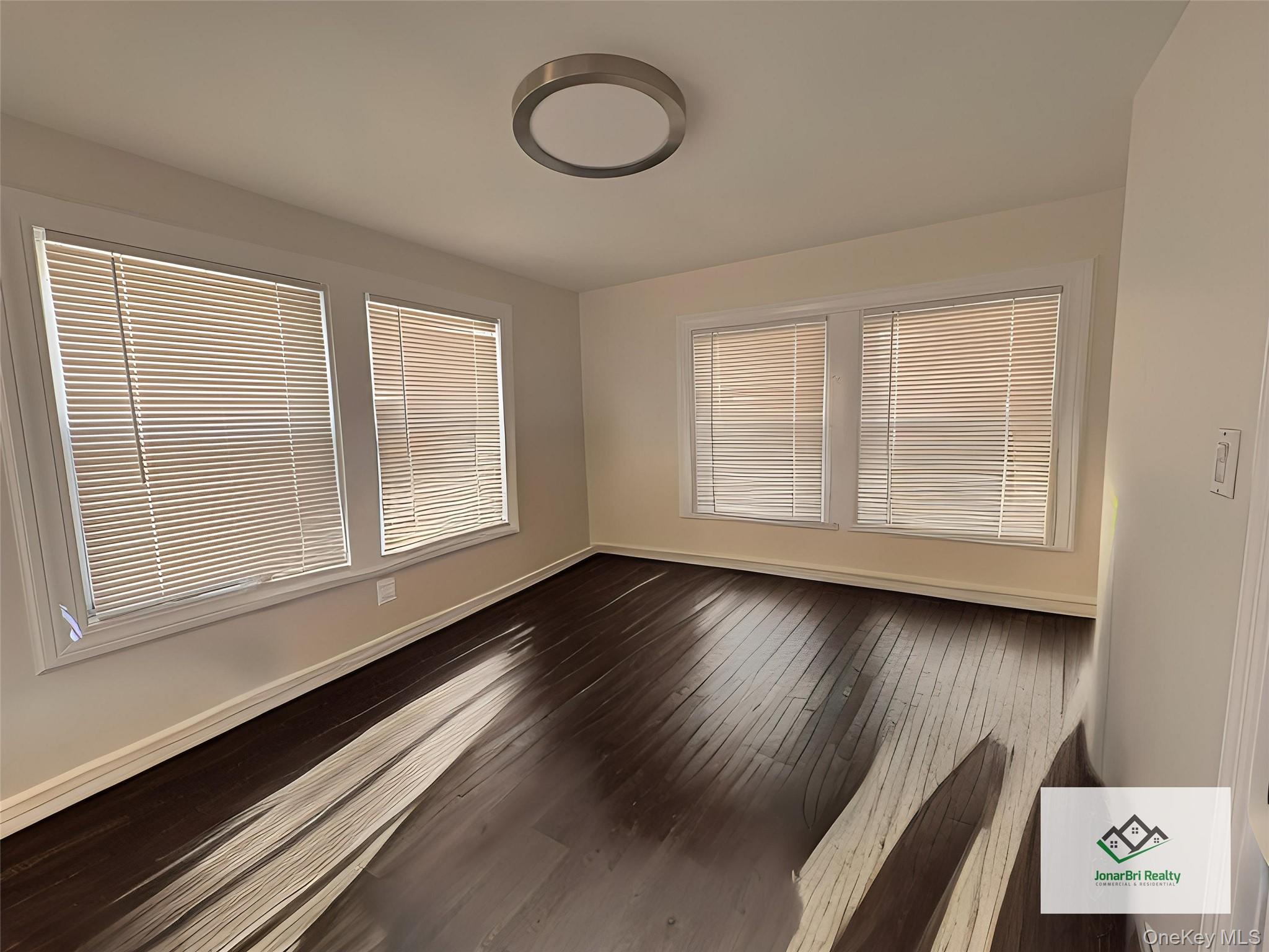 25 Rutland Road Freeport, NY 11520 - Photo 30 of 31 a view of an empty room with wooden floor and a window