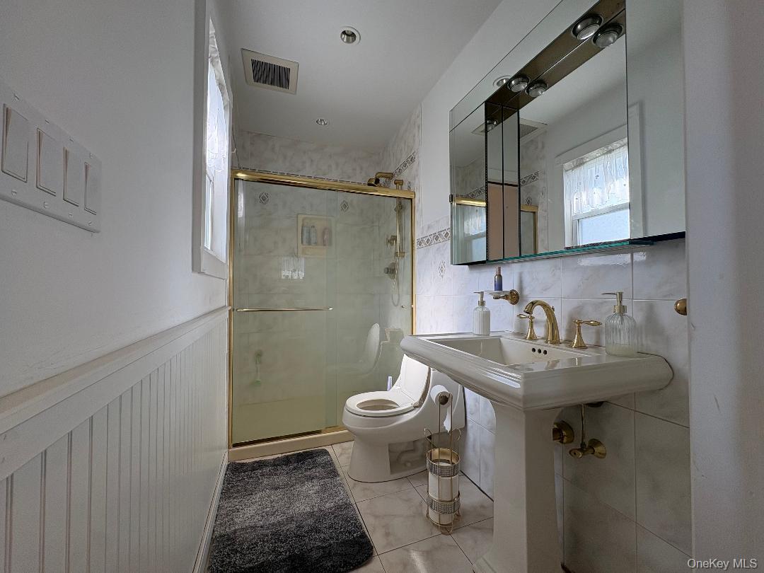 25 Rutland Road Freeport, NY 11520 - Photo 6 of 31 a bathroom with a sink toilet and a mirror