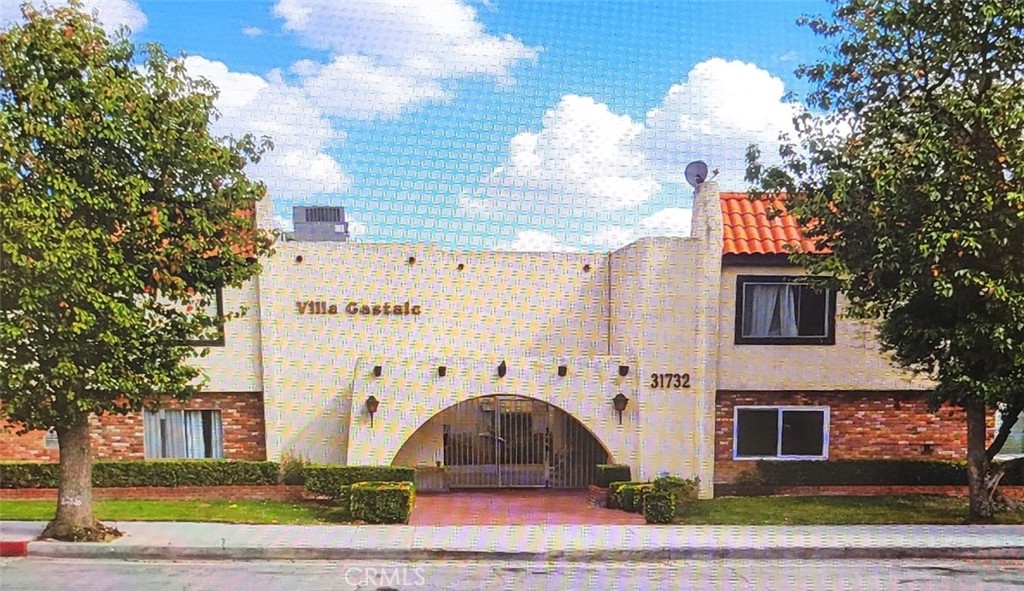 31732 Ridge Rte Road, Unit 211 Castaic, CA 91384 - Photo 2 of 9 a front view of a house with a garden