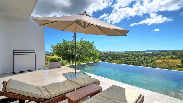 a front view of a house with swimming pool and porch with furniture