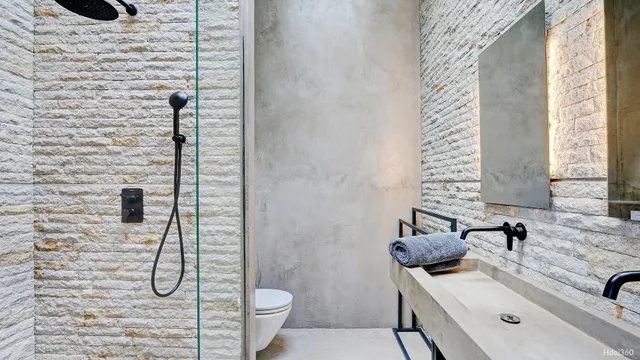 a bathroom with a granite countertop sink a toilet and shower