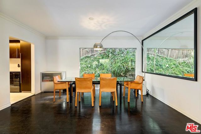 a dining room with wooden floor a glass table and chairs