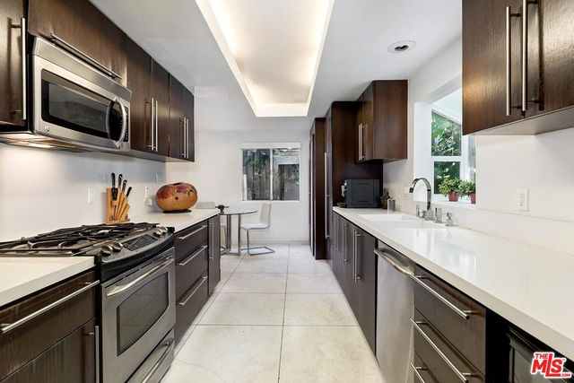 a kitchen with stainless steel appliances granite countertop a stove a sink and a refrigerator
