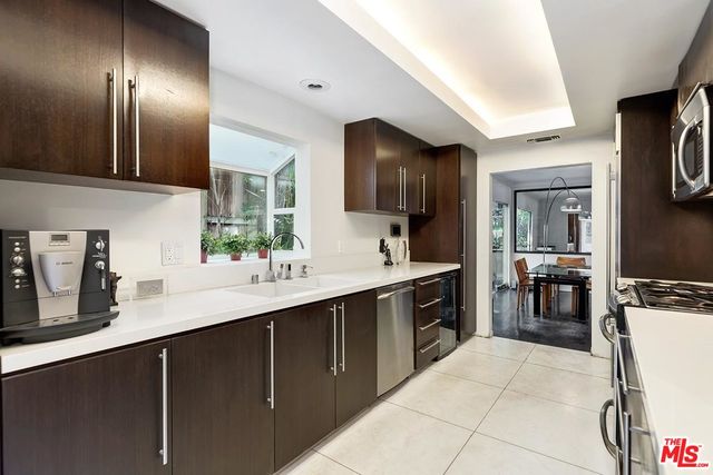 a kitchen with a sink stainless steel appliances a counter space and cabinets