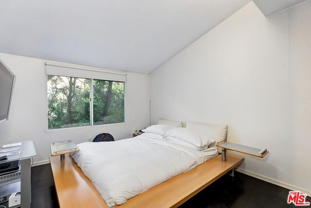 a bed sitting in a bedroom next to a window