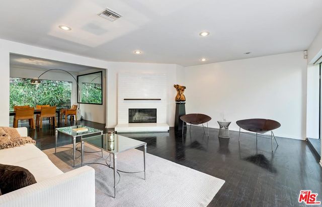 a living room with furniture a table and a large window