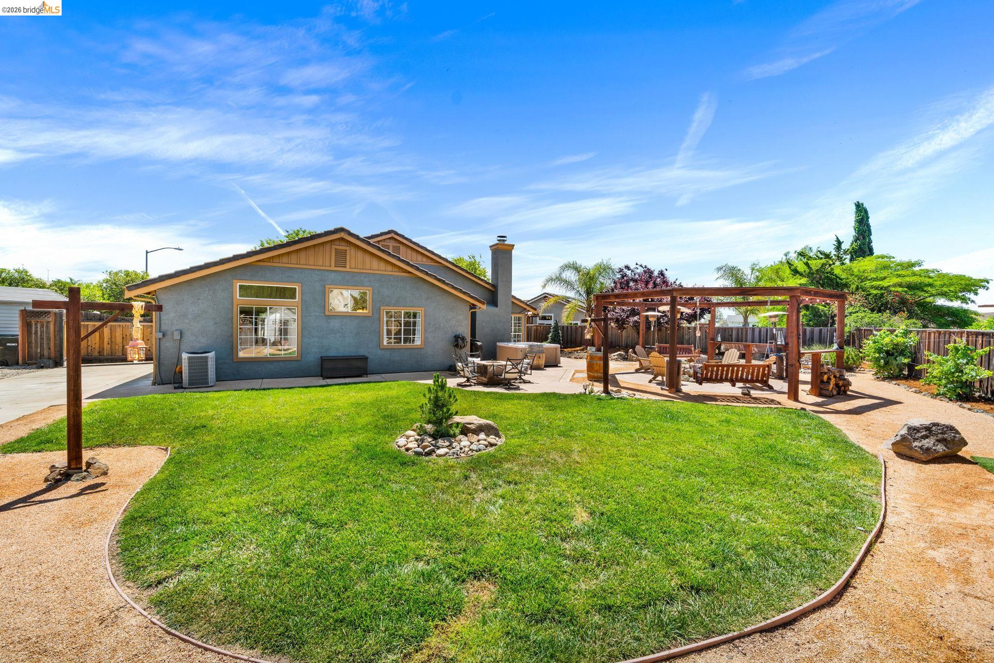 1186 El Rio Court Livermore, CA 94551 - Photo 43 of 60 Spacious backyard featuring a manicured lawn, a large wood pergola, and a gravel pathway