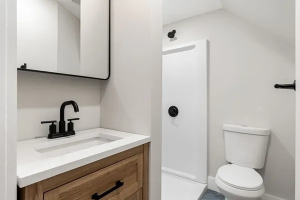 a bathroom with a toilet sink and mirror