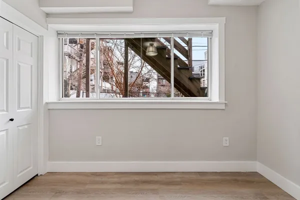 an empty room with wooden floor and a window