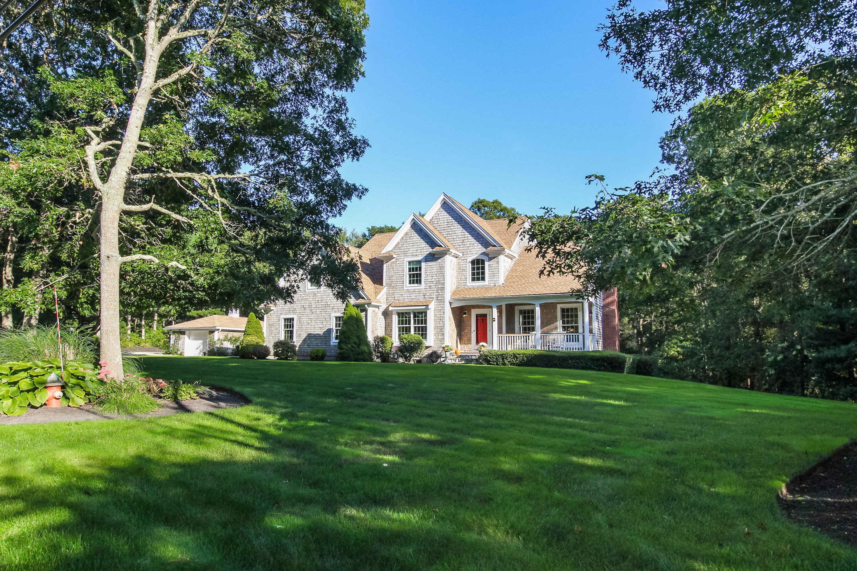 694 Santuit Road Cotuit, MA 02635 - Photo 3 of 35 a front view of a house with a garden