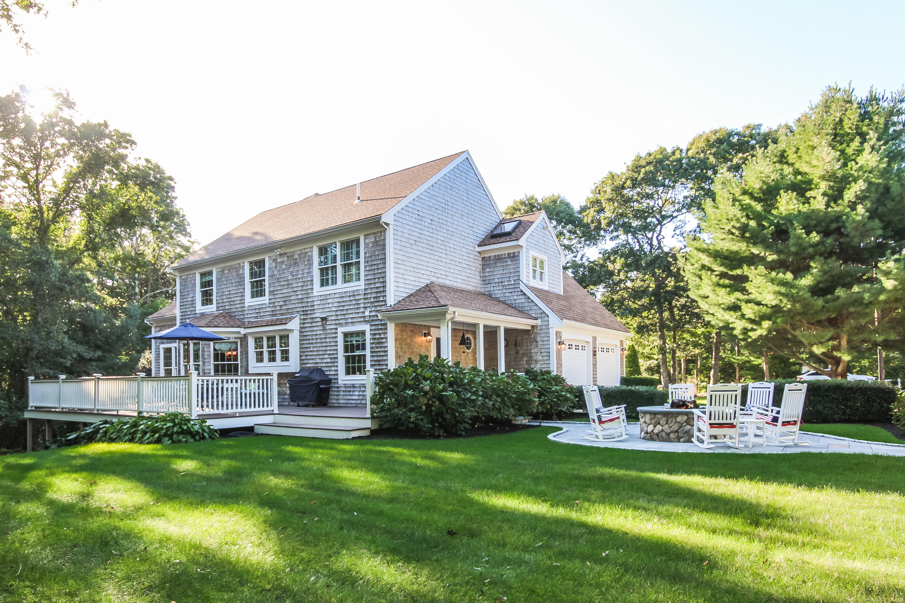 694 Santuit Road Cotuit, MA 02635 - Photo 4 of 35 a front view of a house with a garden and trees