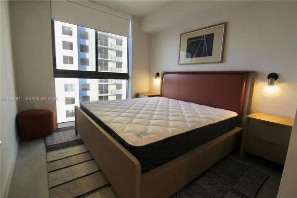 a bed sitting in a bedroom next to a lamp