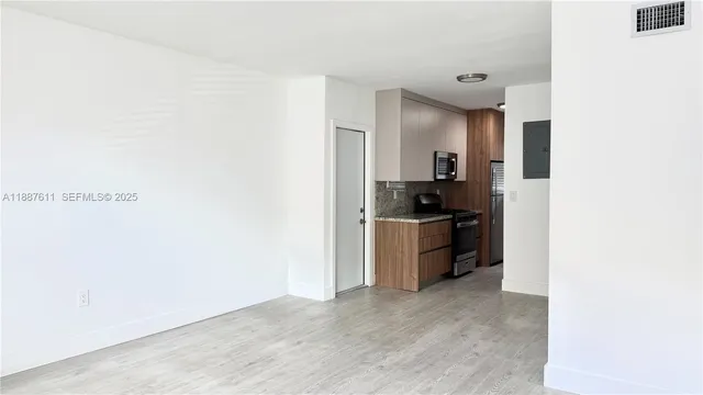 a kitchen with a refrigerator and a stove top oven
