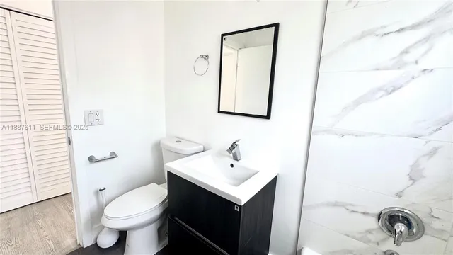 a bathroom with a toilet sink and mirror