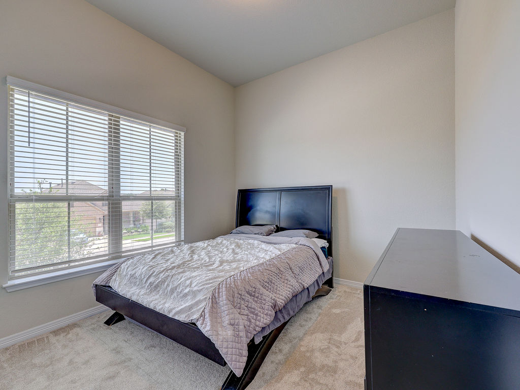 229 Heartleaf Road San Marcos, TX 78666 - Photo 36 of 40 A naturally illuminated bedroom offers peaceful views of the surrounding neighborhood through wide windows.