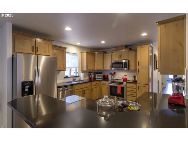 a kitchen with stainless steel appliances granite countertop refrigerator sink and cabinets
