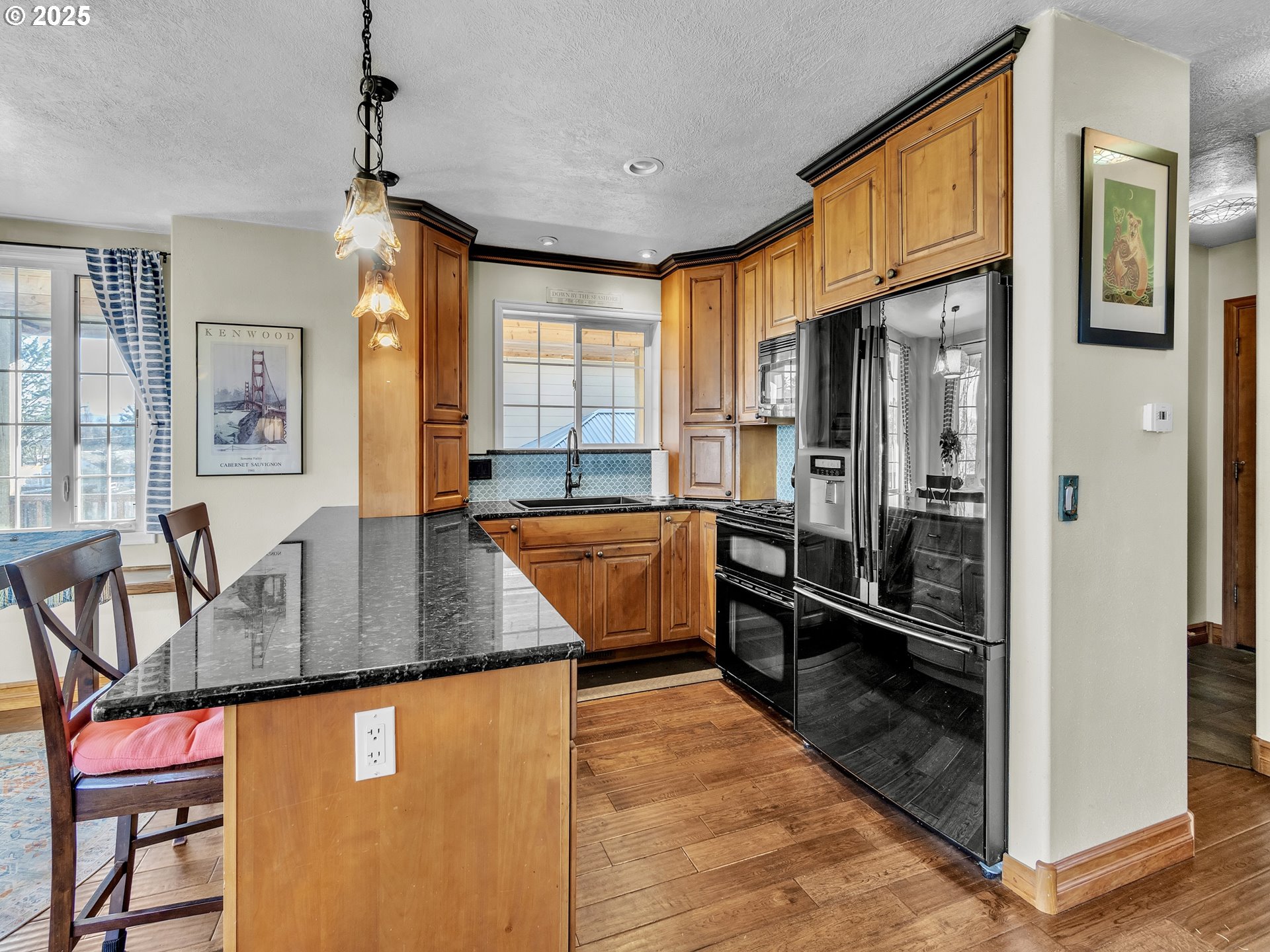 90589 Clark Road Warrenton, OR 97146 - Photo 27 of 48 a kitchen with stainless steel appliances granite countertop a refrigerator a stove and a sink with wooden floor