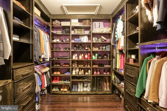 a view of walk in closet with clothes and shoes