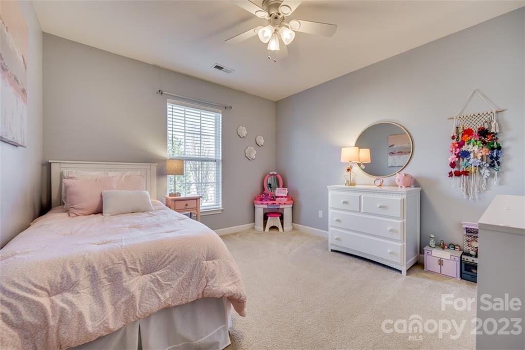 106 Anchura Road Fort Mill, SC 29708 - Photo 23 of 30 a bedroom with a bed and a chandelier