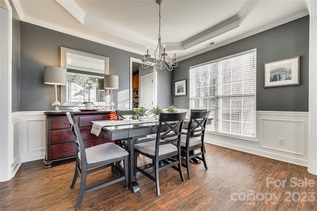 106 Anchura Road Fort Mill, SC 29708 - Photo 5 of 30 a dining room with wooden floor a chandelier a wooden table and chairs