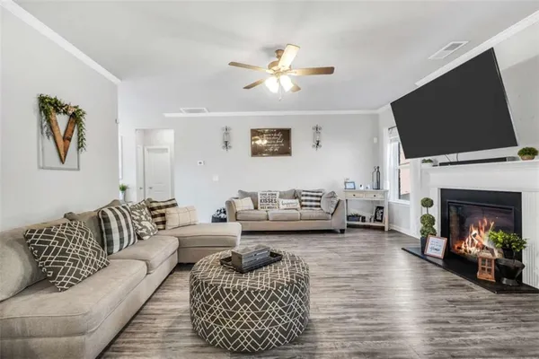 a living room with furniture a flat screen tv and a fireplace