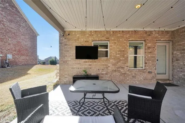 a brick house with table and chairs in wooden floor
