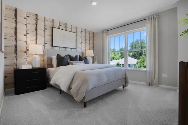 a bedroom with a bed lamp and a large window