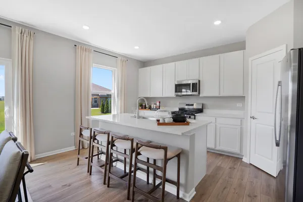 a kitchen with white cabinets and stainless steel appliances
