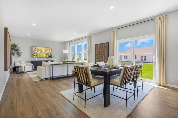 a view of a dining room with furniture a chandelier and wooden floor