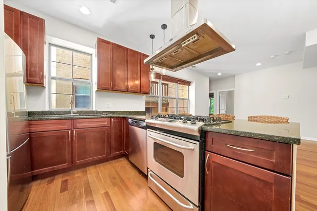 a kitchen with granite countertop cabinets stainless steel appliances a sink and a window