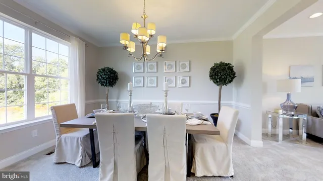 a view of a dining room with furniture a chandelier and large windows