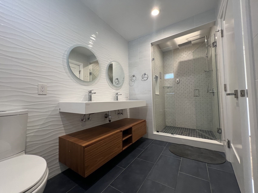 23 Winslow Road, Unit 1 Brookline, MA 02446 - Photo 13 of 27 a bathroom with a double vanity sink mirror and toilet