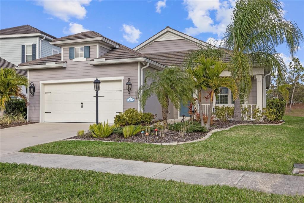 13185 Steinhatchee Loop Venice, FL 34293 - Photo 11 of 50 a front view of a house with a garden and palm trees