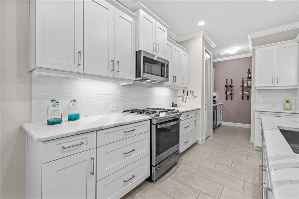 13185 Steinhatchee Loop Venice, FL 34293 - Photo 20 of 50 a kitchen with granite countertop white cabinets stainless steel appliances and sink