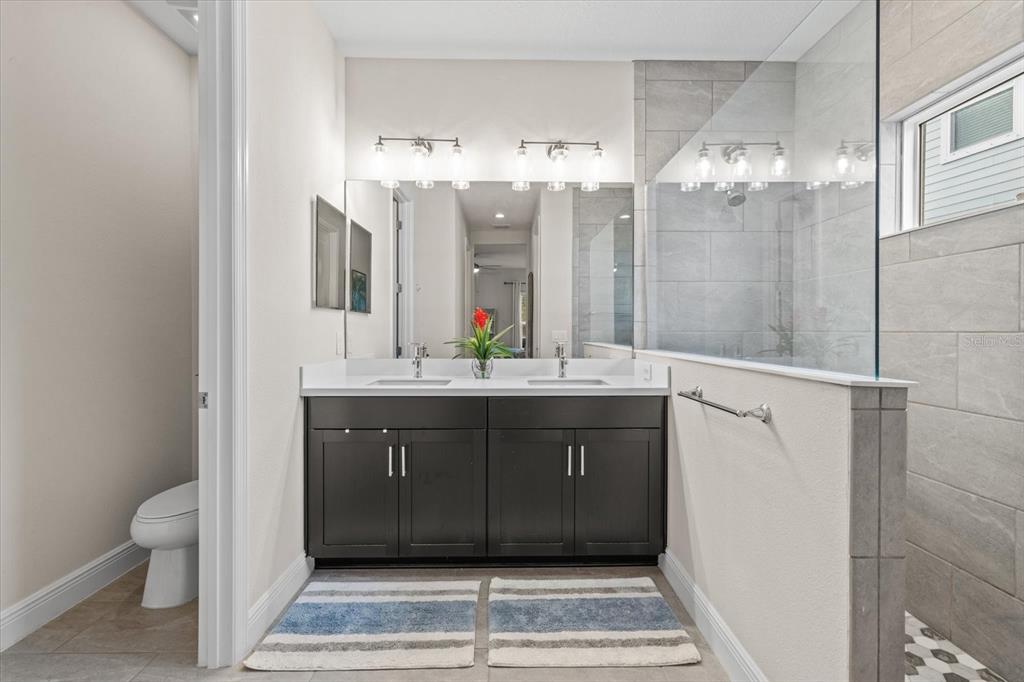 13185 Steinhatchee Loop Venice, FL 34293 - Photo 32 of 50 a bathroom with a double vanity sink and a mirror