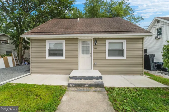 a front view of a house with a yard and trees