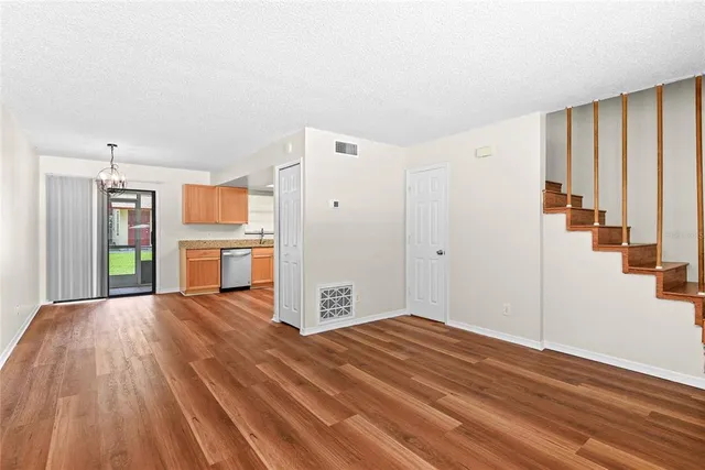 a view of a livingroom with wooden floor and a fireplace