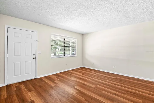 wooden floor in an empty room with a window