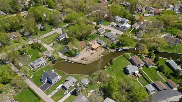 an aerial view of lake and residential houses with outdoor space
