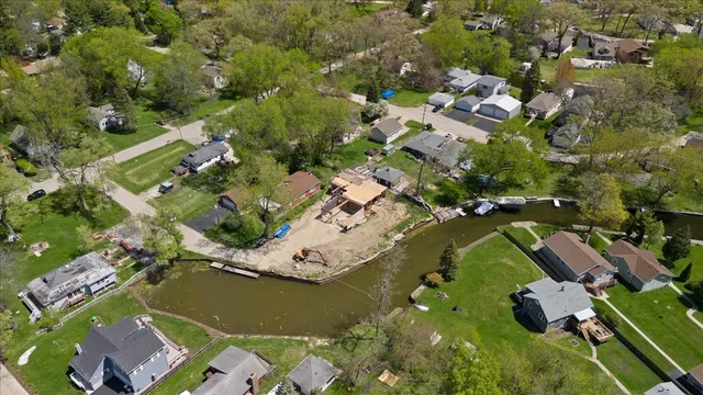 an aerial view of residential houses with outdoor space and trees